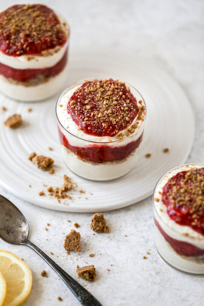 A tray of blender lemon vegan mousse topped with crushed gluten-free cookies and homemade berry sauce.